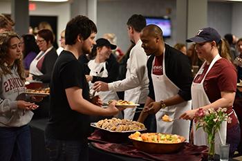 workers in cafeteria serving food to students